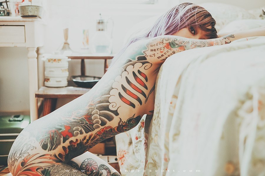 Брюнетка с татуировками отдыхает дома голой