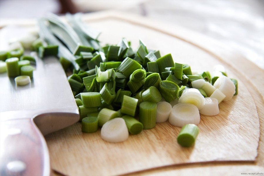 Рецепты зелени чеснока. Пюре из чеснока. A White Bowl filled with Chopped garlic.