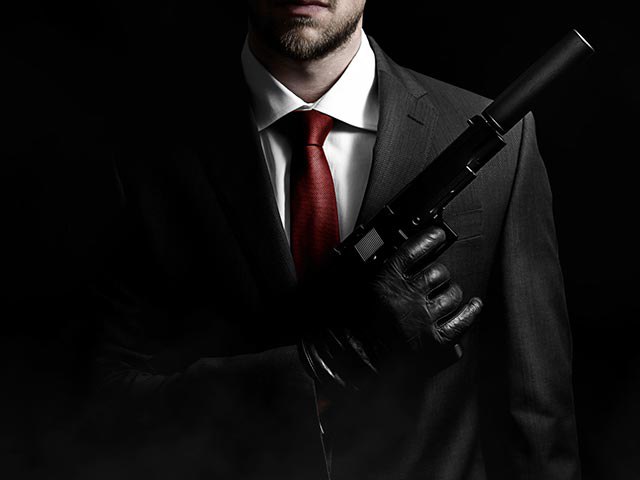 Мужчина в костюме с пистолетом
