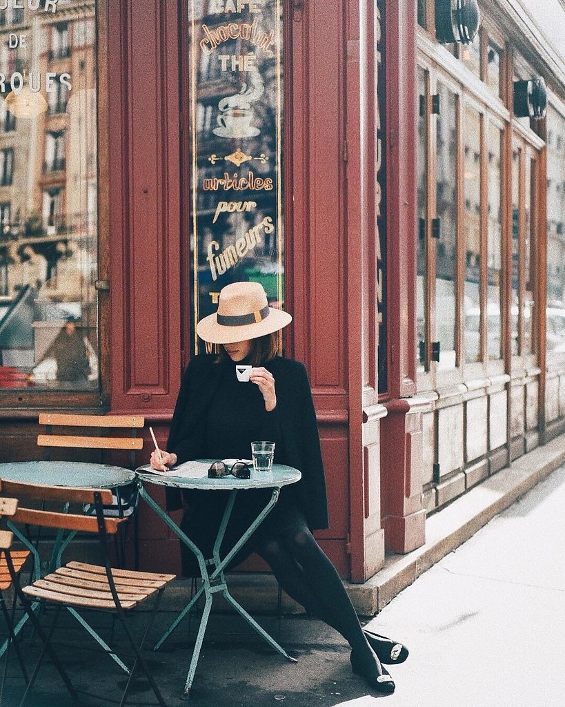 Девушка в кафе в Париже осенью