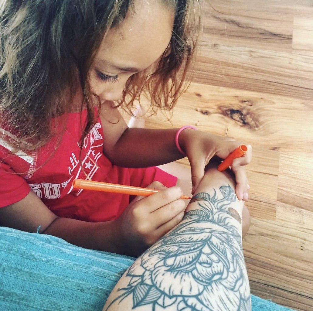 Ребенок раскрашивает татуировку