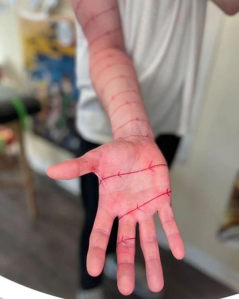 татуировка красная проволока на руке