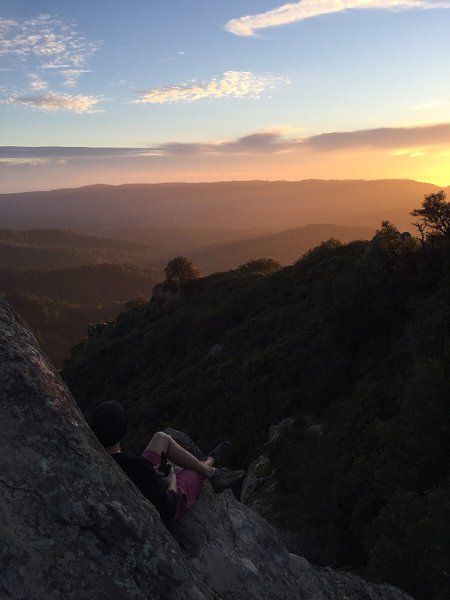 A climber savors his summit at the top of Goat Rock at Castle Rock State Park, CA